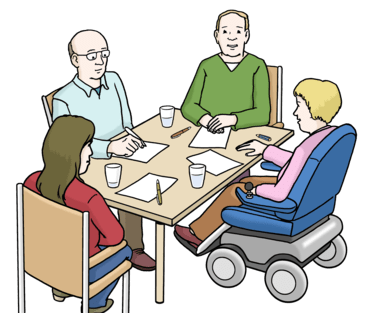 Vier Personen sitzen zusammen am Tisch und arbeiten.