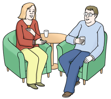 Zwei Personen sitzen bei einem Gespräch zusammen.